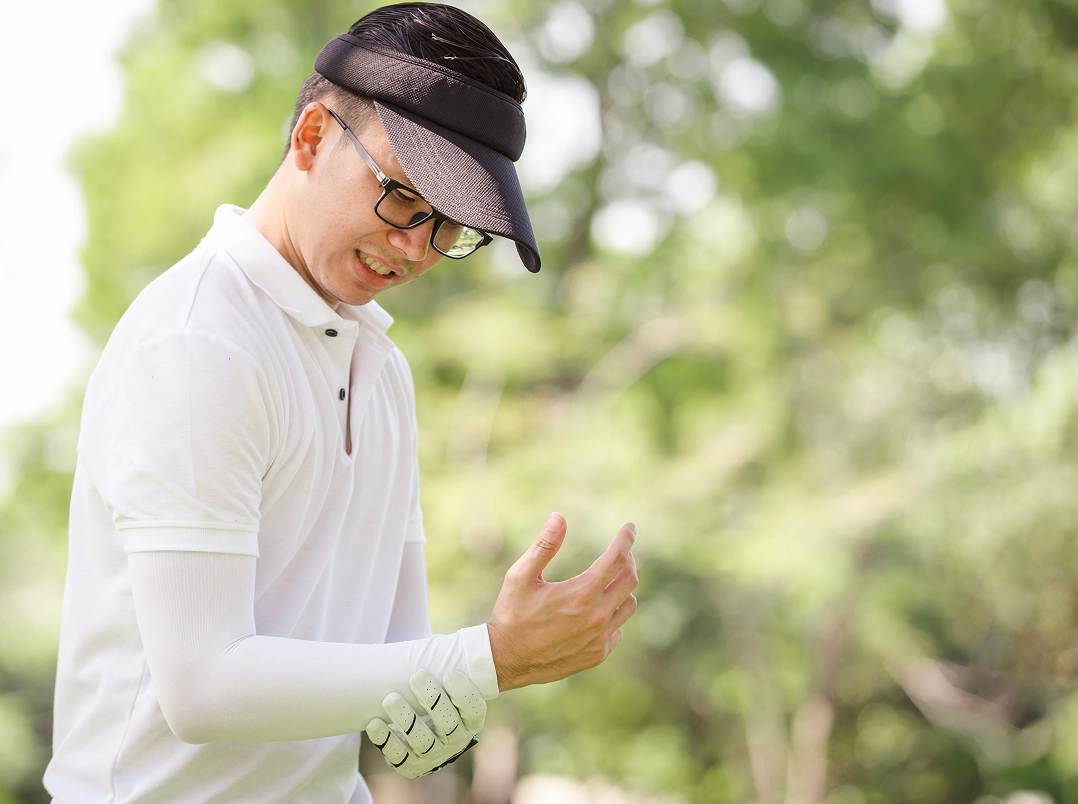 Male golfer holding his wrist - Baytown, TX Orthopaedic Hand, Wrist & Elbow Surgery