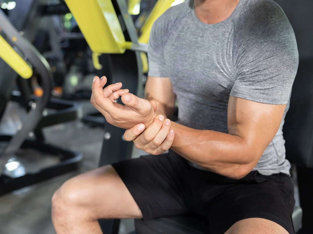 Man in gym holding wrist - Bellaire, TX Orthopaedic Hand, Wrist & Elbow Surgery