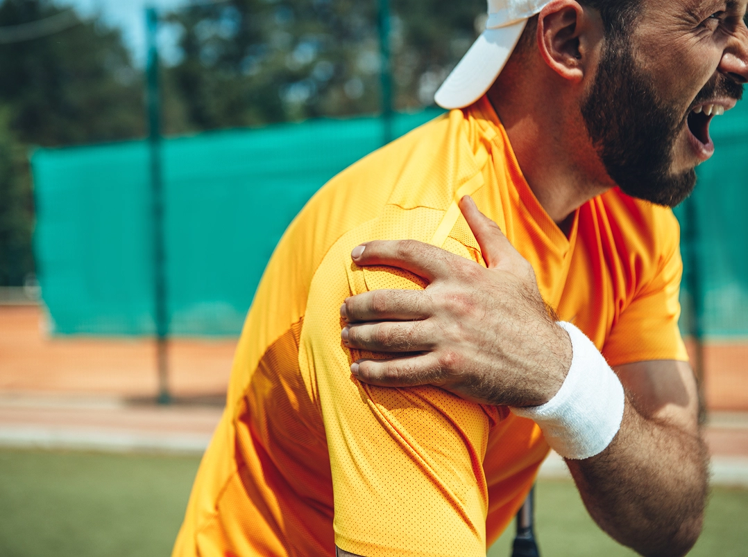 Tennis player holding onto his shoulder - Clear Lake, TX Orthopaedic Hand, Wrist & Elbow Surgery