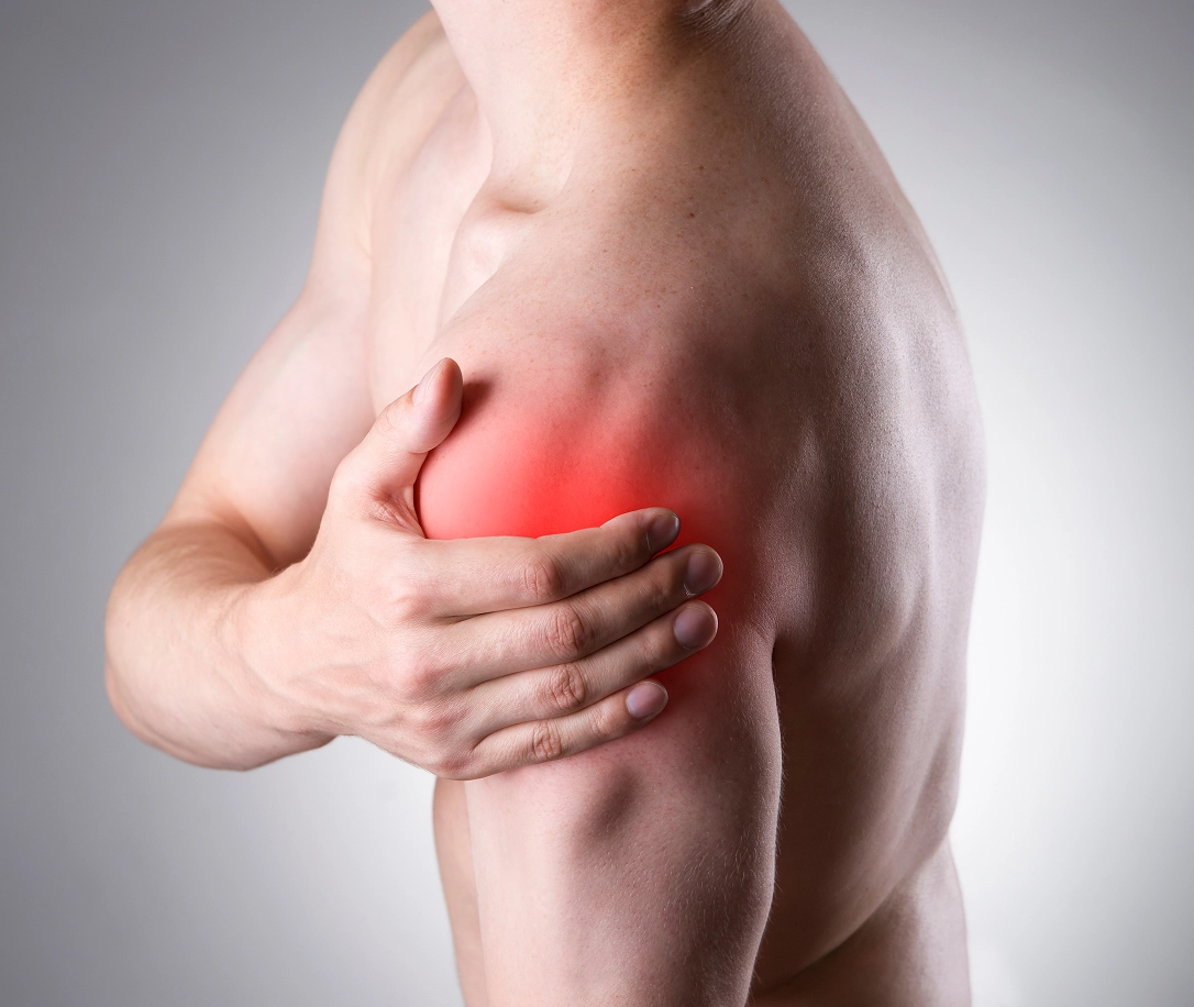 Man holding his shoulder highlighted in red to show pain, orthopedic shoulder treament and surgery