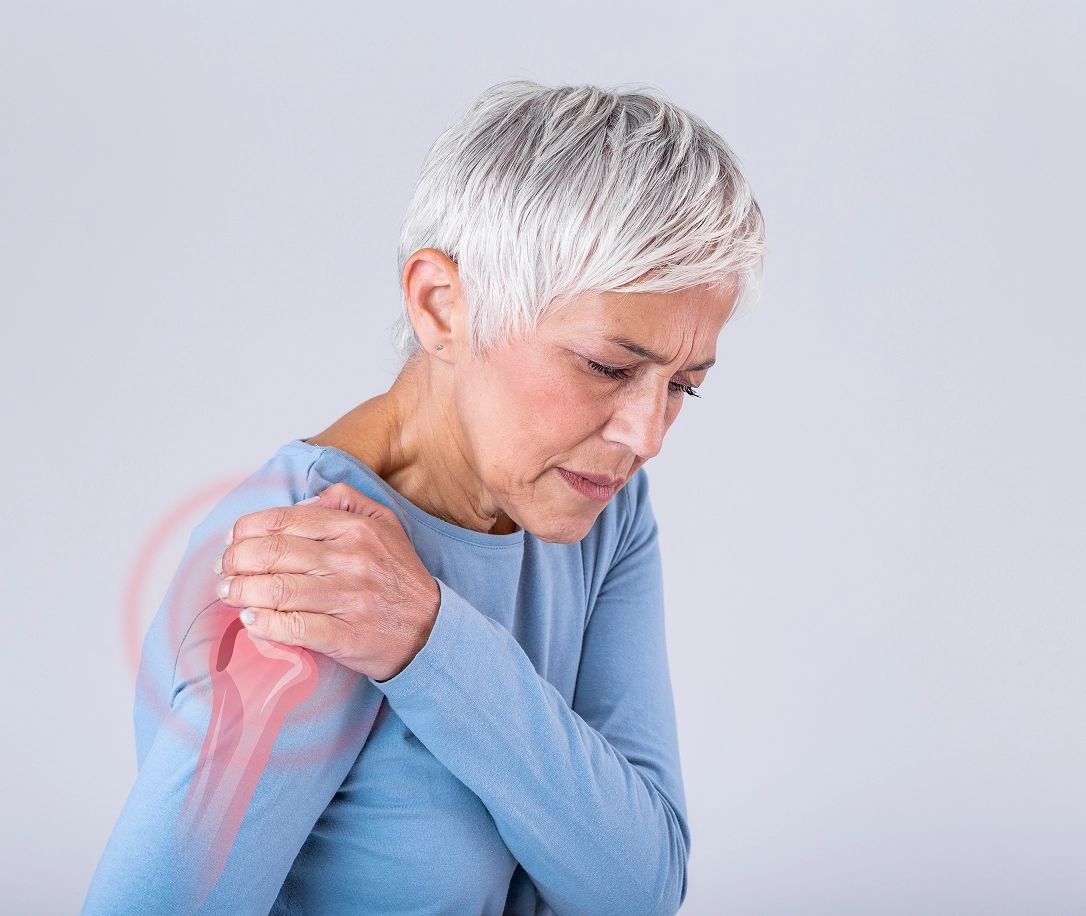 Older woman grabbing her shoulder in pain