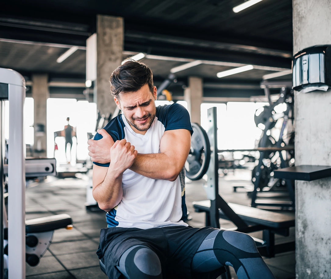 Man at the gym grabbing shoulder in pain