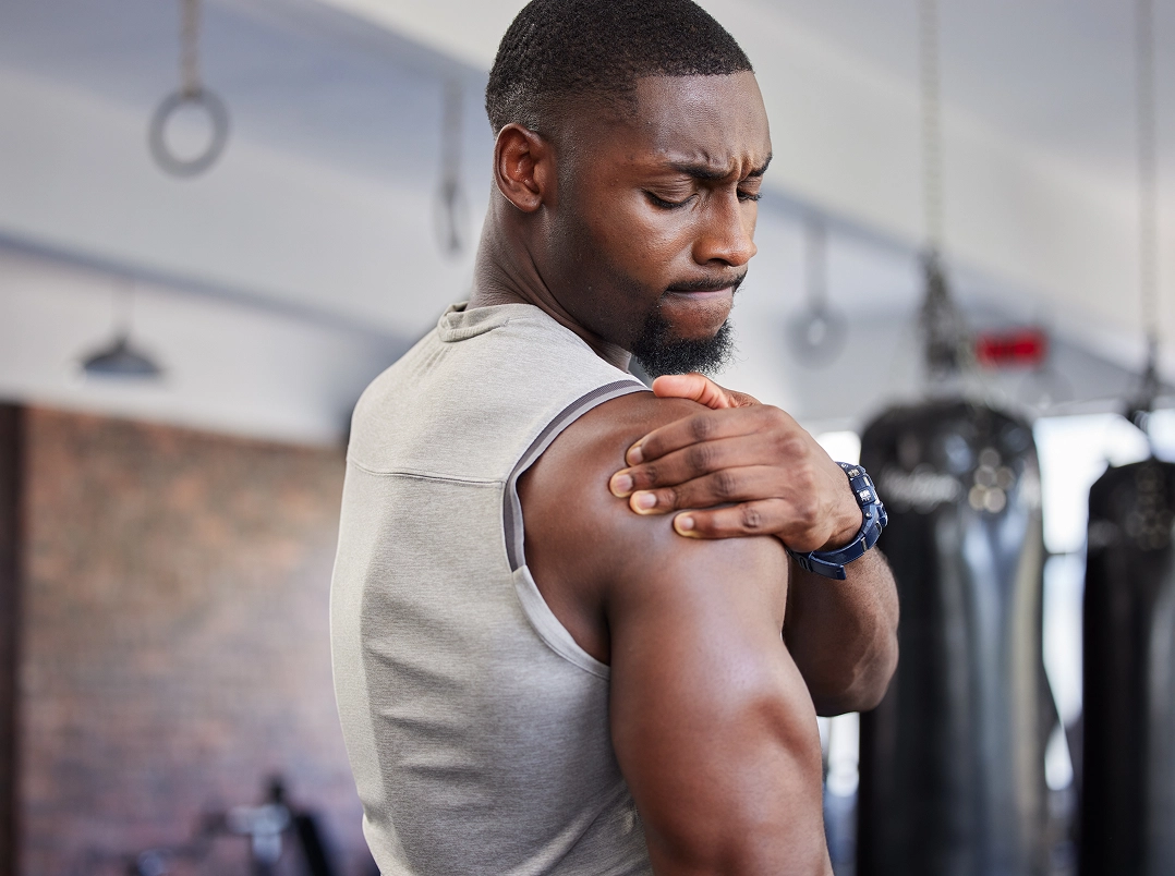 man at the gym holding his shoulder - League City, TX Orthopaedic Hand, Wrist & Elbow Surgery