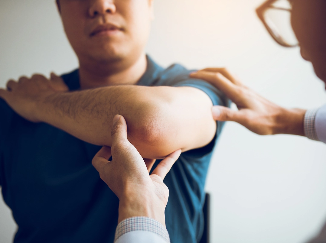 doctor holding patient's elbow - Orthopaedic Hand, Wrist & Elbow Surgery