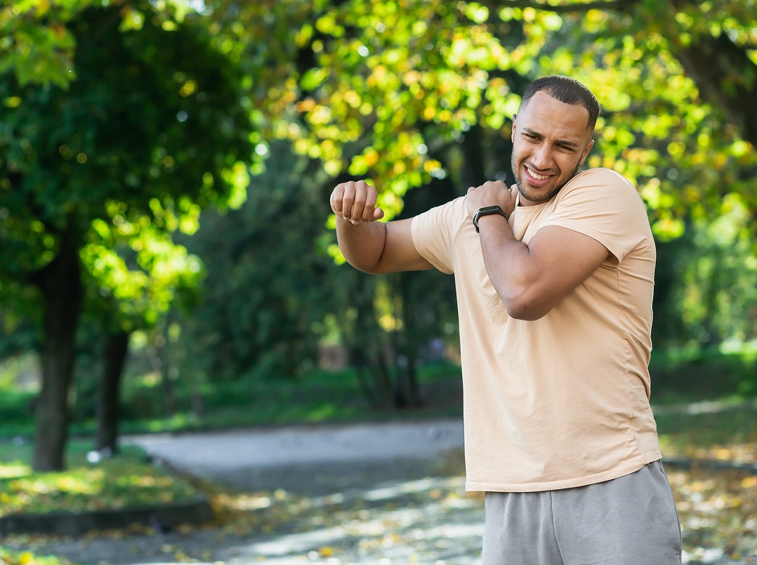 Man holding shoulder while lifting his arm - Missouri City, TX Orthopaedic Hand, Wrist & Elbow Surgery