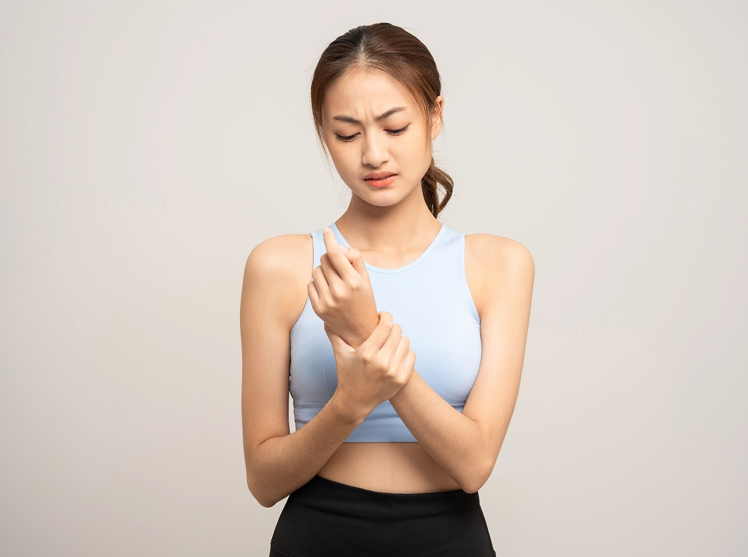 young woman holding her wrist - Willowbrook, TX Orthopaedic Hand, Wrist & Elbow Surgery